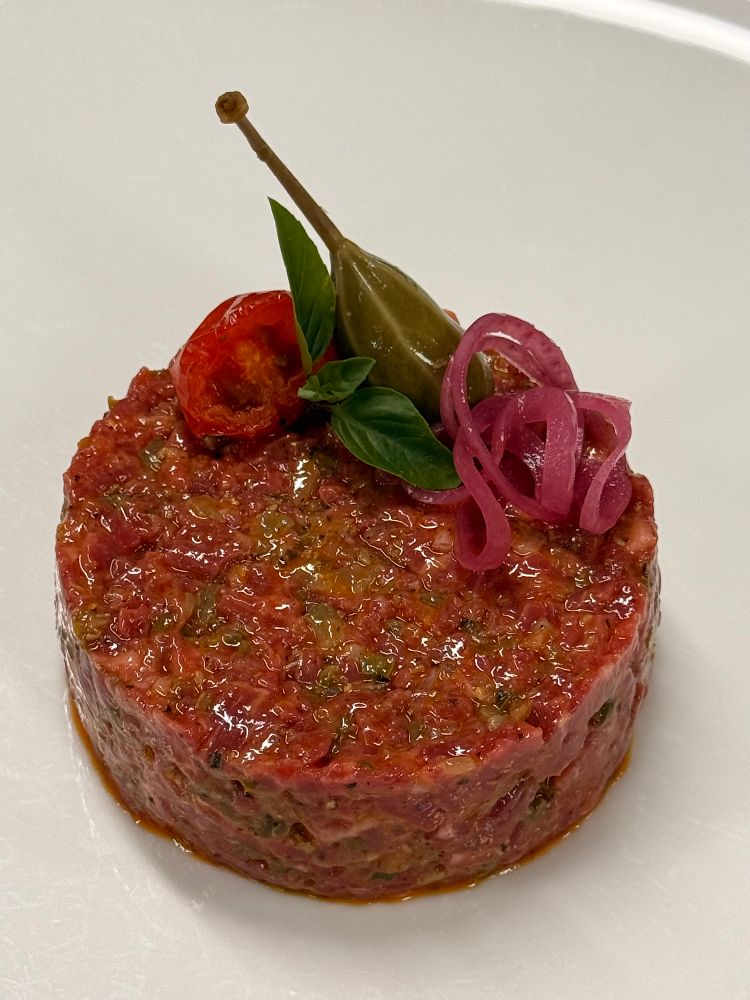 Frisch angerichtetes Tatar mit Kapernbeere und roten Zwiebeln